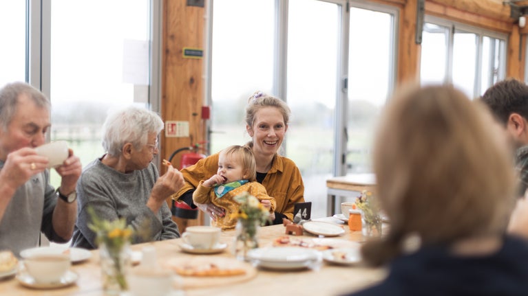 A lady with a baby eating in the cafe at Tinkley Gate